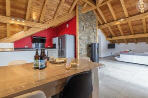 Een moderne keuken met een accentmuur van steen, een houten plafond en een rode accentmuur.
