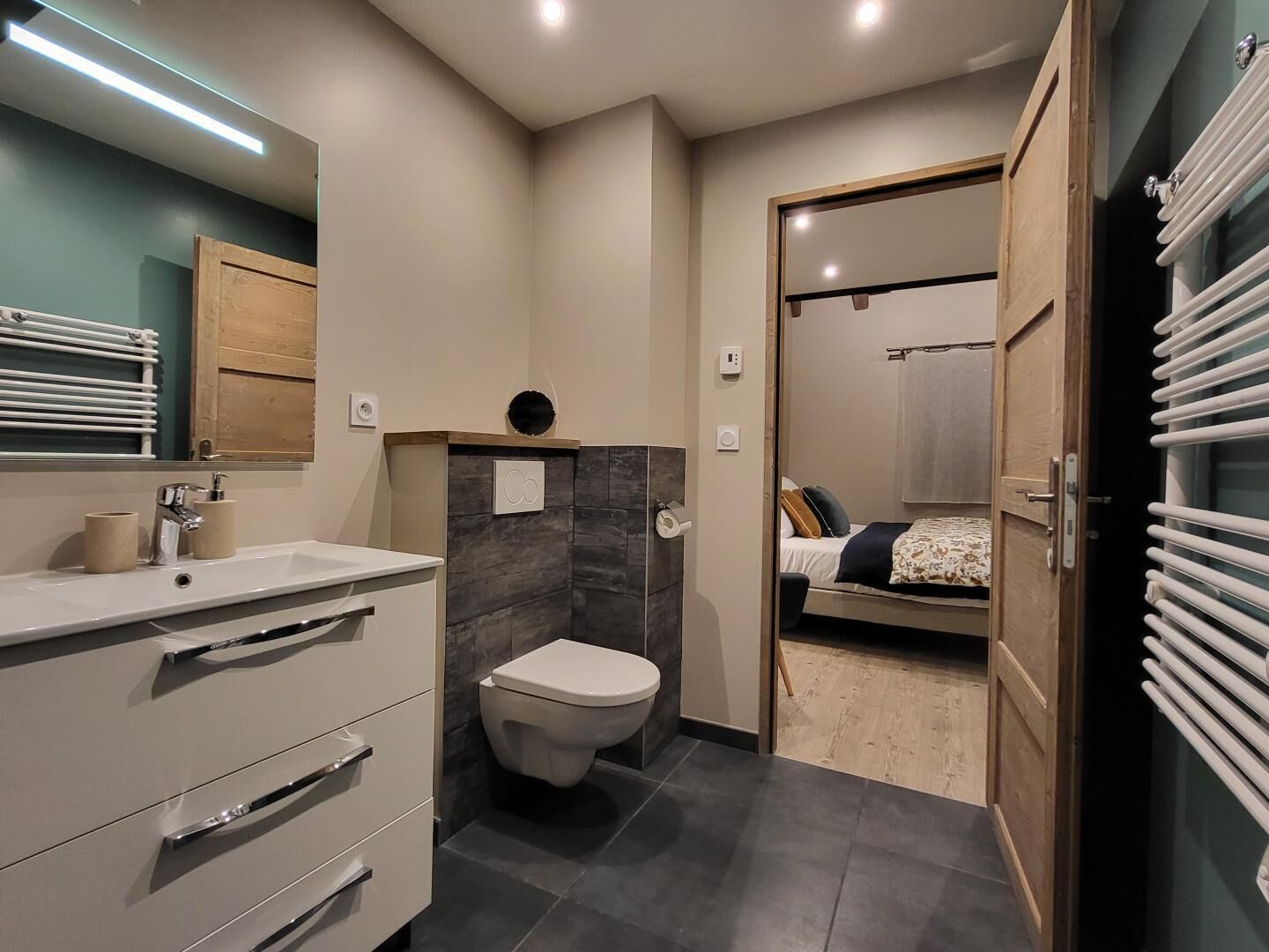 Ein modernes Badezimmer mit Toilette, Waschbecken und Spiegel.