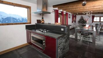 Una cocina moderna con una isla central, horno empotrado y campana extractora de acero inoxidable.
