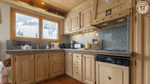 Una cocina con armarios de madera, encimeras de granito y lavavajillas Bosch.