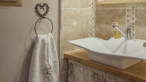 A bathroom with a wooden ceiling, a white sink, and a mirror above it.