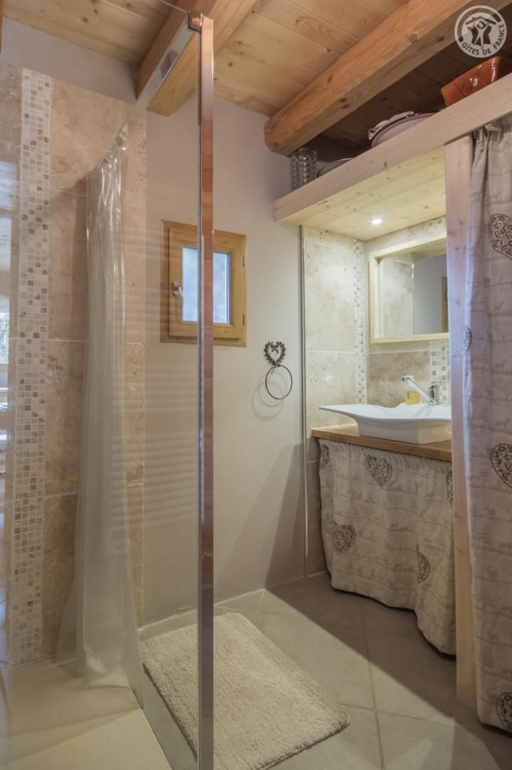 Un bany amb dutxa, un lavabo i un mirall.