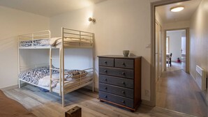 Una habitación con literas y un aparador.