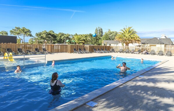 Una piscina al aire libre de temporada, sillones reclinables de piscina