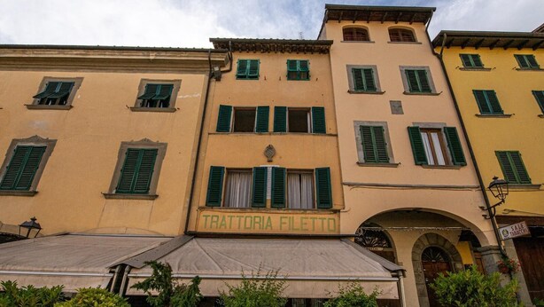 A building with a sign reading "TRATTORIA FILETTO" and an archway entrance.