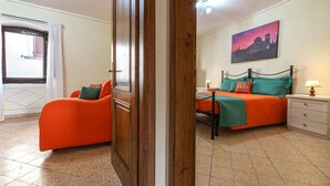Une chambre à coucher avec un lit, une table de chevet, une chaise et un tableau au mur.