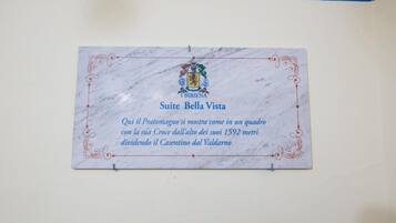 A marble plaque with a coat of arms and text in Italian, mounted on a wall.