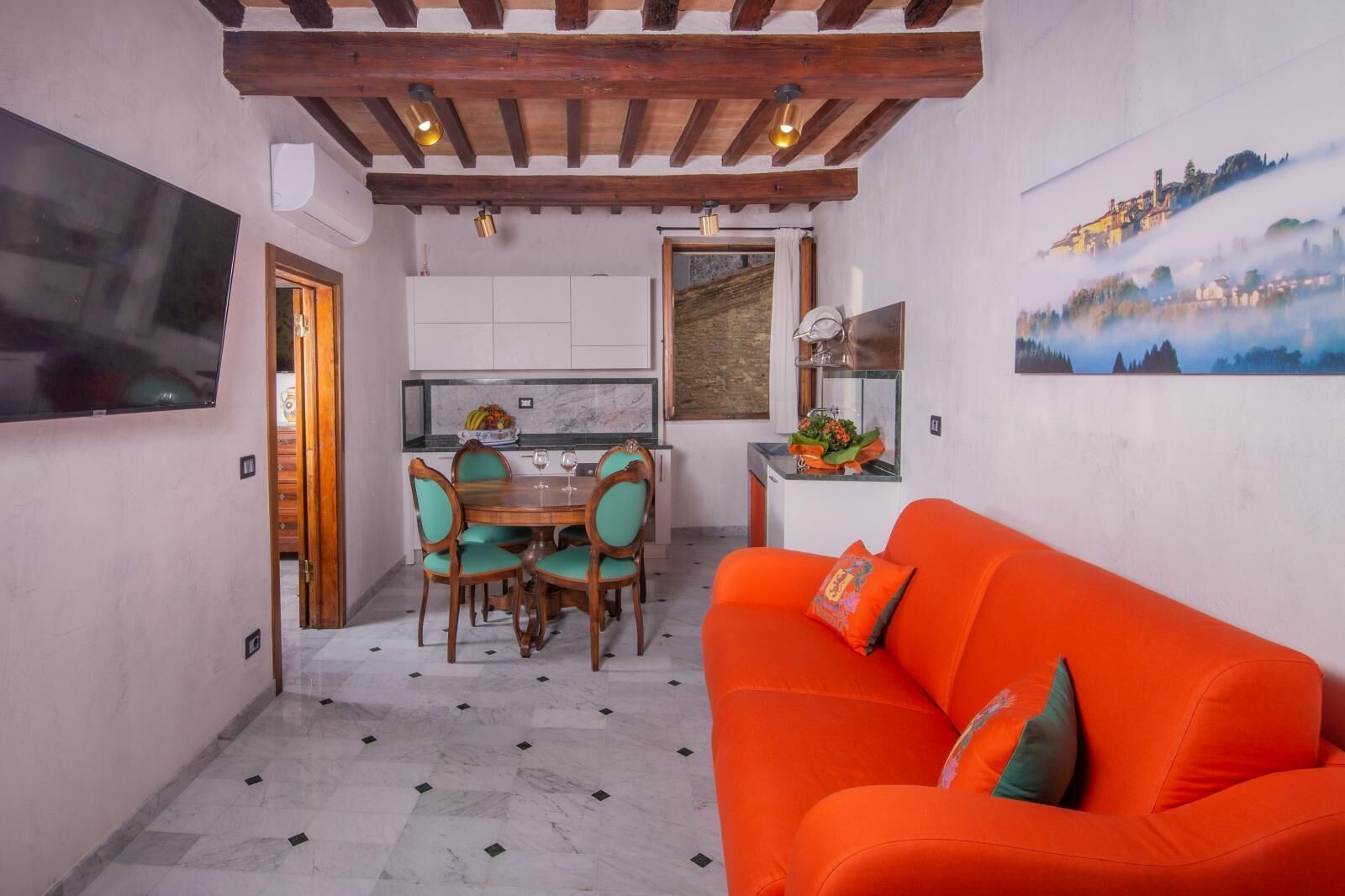 Un espacio habitable compacto con comedor, sofá y cocina.