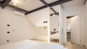 Une chambre avec un lit superposé, une porte dotée d’une poignée et un interrupteur sur le mur.