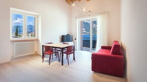 Un salon moderne avec un coin repas, un canapé rouge et un téléviseur.