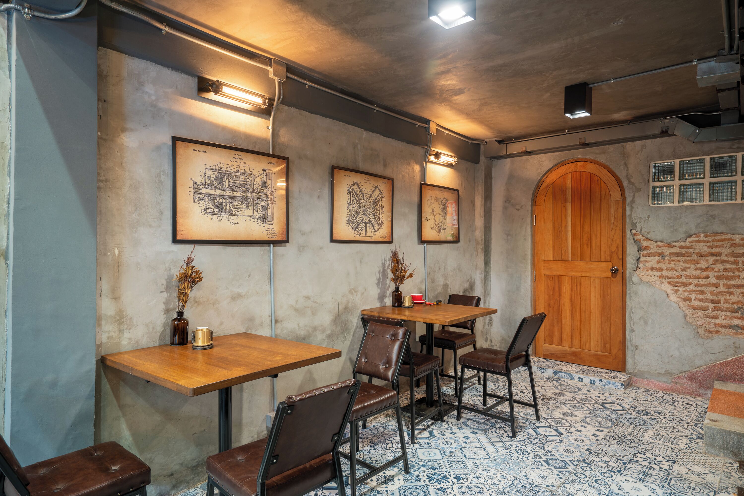 A cozy restaurant with wooden tables and chairs, framed artwork on the walls, and a rustic brick wall.