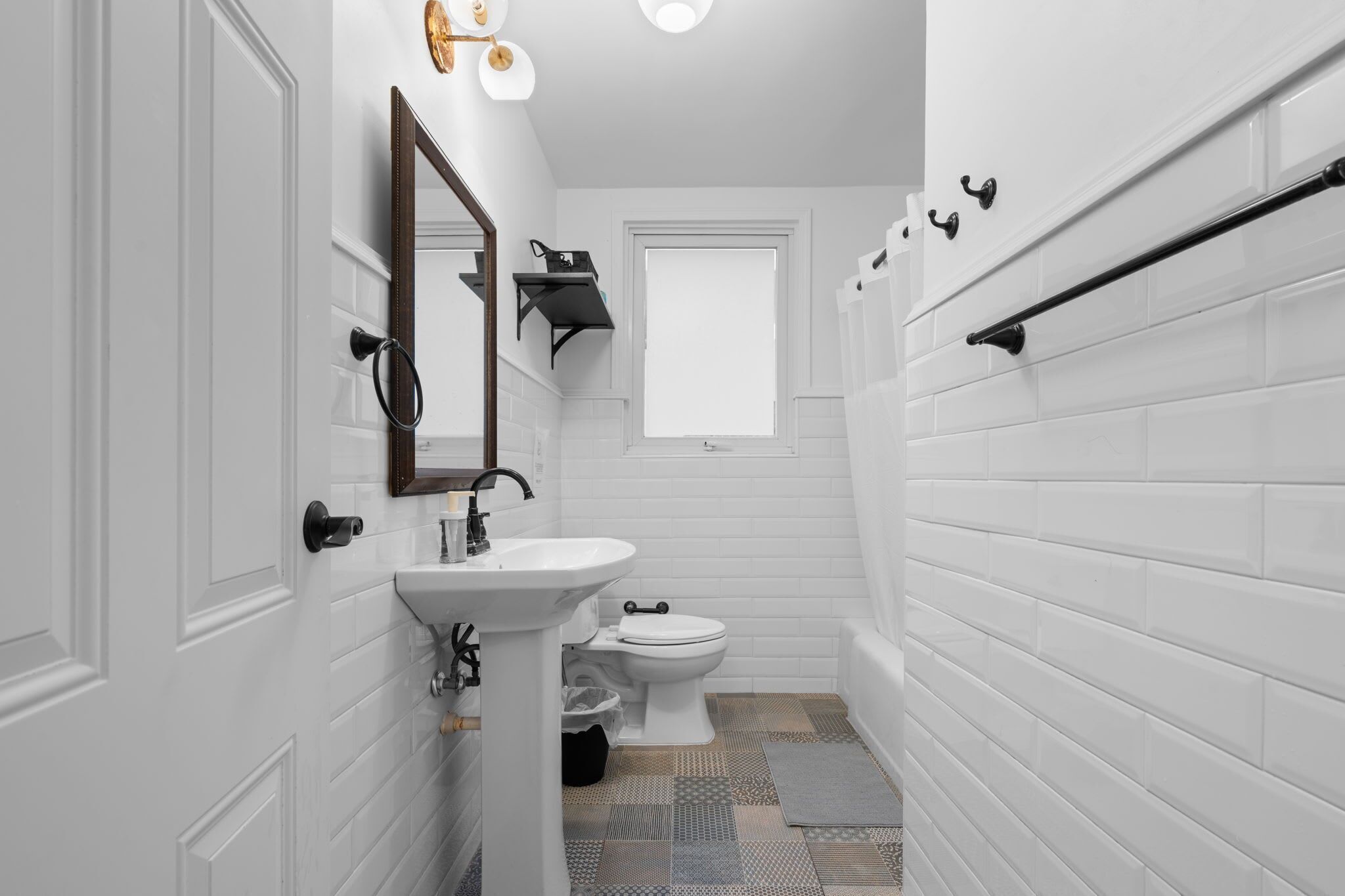 A compact bathroom with a white sink, a toilet, and a mirror.