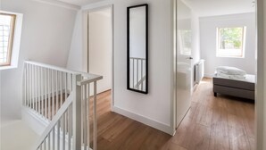 A modern interior with a staircase, a hallway leading to a bedroom, and a large mirror. - Gorgeous home in Den Oever with WiFi (Den Oever)