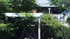 A house with a covered porch and a white fence. - Coastal Queenslander- 2 minute walk to the beach! (Woodgate)