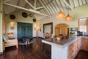 Una cocina amplia con una isla grande, armarios de madera y un ventilador de techo.