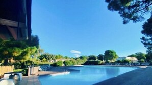 A swimming pool with lounge chairs and a clear blue sky.