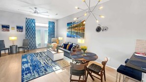 Een moderne woonkamer met een bank, stoelen, een salontafel en een eethoek met tafel en stoelen.