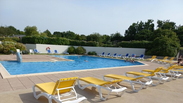 Ein Schwimmbecken mit Liegestühlen und einer Poolanlage.