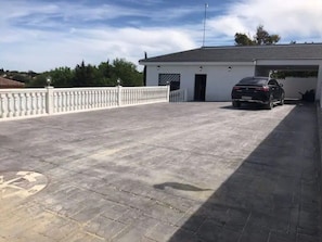 Un espace de stationnement doté d’une surface goudronnée et d’un bâtiment blanc avec un garage.