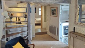 A spacious loft-style room with a high ceiling, a wooden staircase, and a view of the outside. - Apartment + terrace T6 exceptional view/location, waterfront (Collioure)