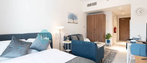 Un dormitorio moderno con una cama grande, mesitas de noche, un escritorio y una silla.