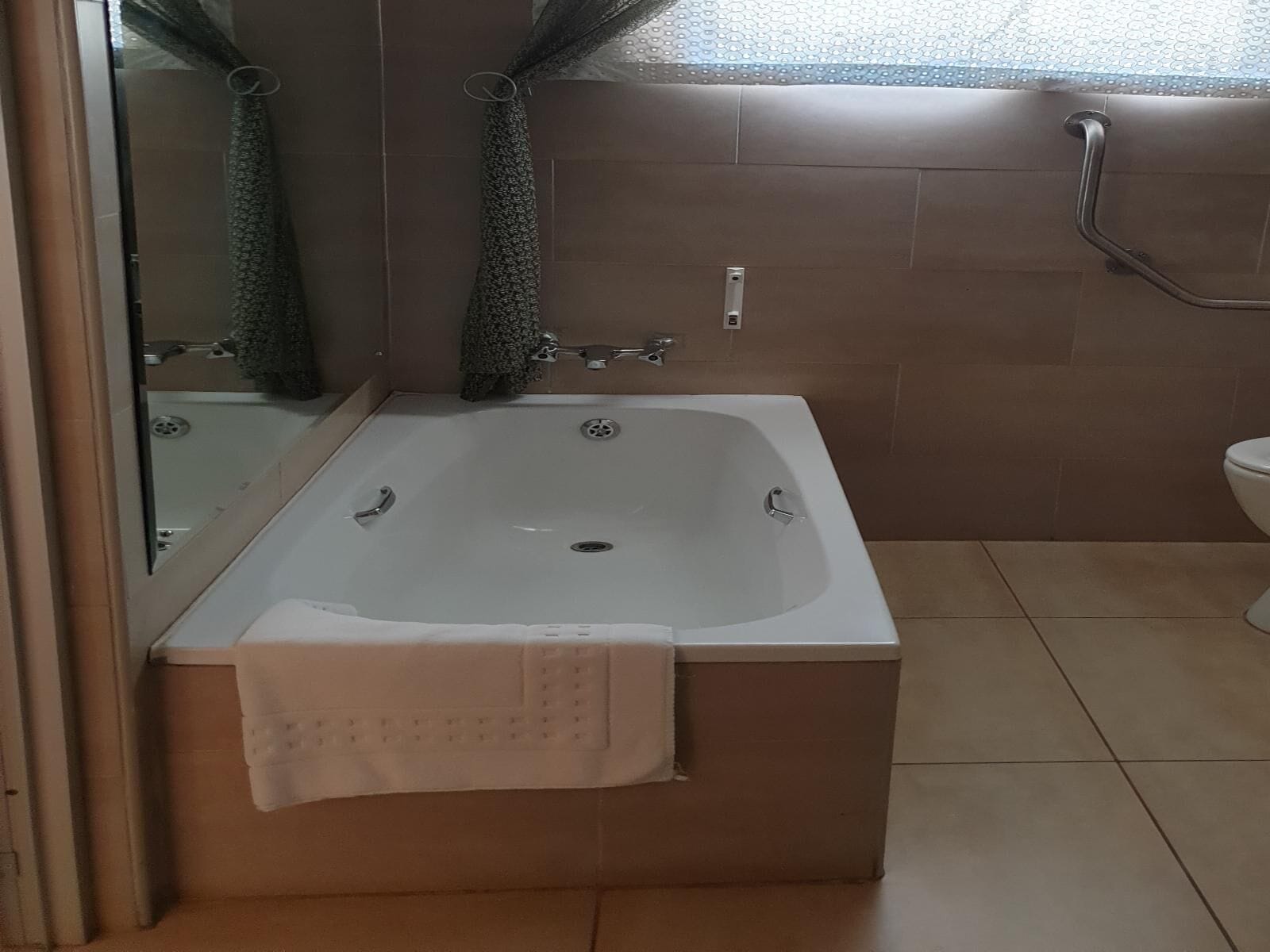 Een badkamer met een bad, toilet en douche.