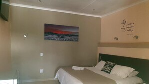 Un dormitorio con cama, un cuadro en la pared y una cita escrita.