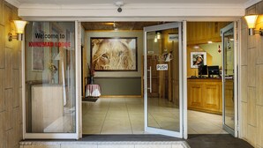 La entrada al Kuruman Lodge, con mostrador de recepción, un botón pulsador y un letrero de bienvenida.