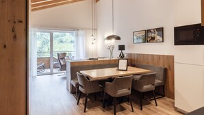 Eine moderne Küche mit einem Holzespeisetisch, Stühlen und einer eingebauten Mikrowelle.