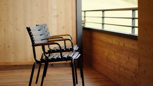 A wooden deck with a metal bench. - Alpenstolz #1.06 Comfort (Damüls)
