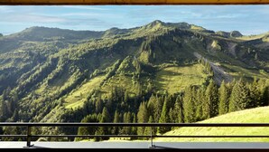 A mountain landscape with a wooden deck and railing. - Alpenstolz #2.01 Comfort (Damüls)