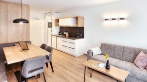 Eine moderne Wohnung mit Essbereich, Küchenzeile und Wohnraum.