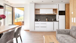Une cuisine moderne avec des armoires blanches, un plan de travail en bois et un four encastré.