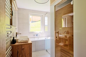 Bathtub, hair dryer, towels, toilet paper
