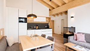 A modern interior with a dining area, kitchen, and living space. - Alpenstolz #3.06 Comfort with Coolfire (Damüls)