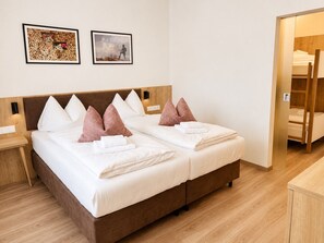 Un lit double avec deux oreillers, une tête de lit en bois, une table de chevet et un plancher en bois.