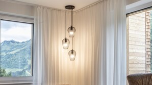 Un salon moderne avec un canapé d’angle, une petite table et une vue sur l’extérieur.