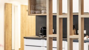 Una cocina moderna con armarios de madera, una cafetera y una vinoteca.