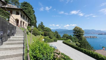 Un bâtiment doté d’un escalier en pierre menant à une terrasse qui offre une vue sur un lac.