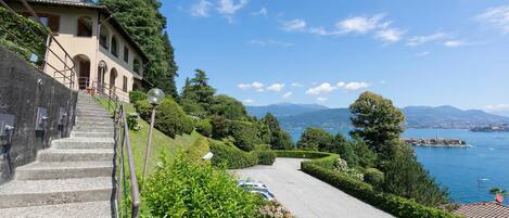 A building with a stone staircase leading to a terrace overlooking a lake.