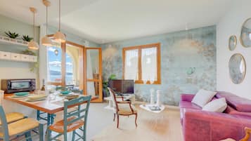 Un salon moderne comprenant un coin repas, un canapé et un téléviseur.