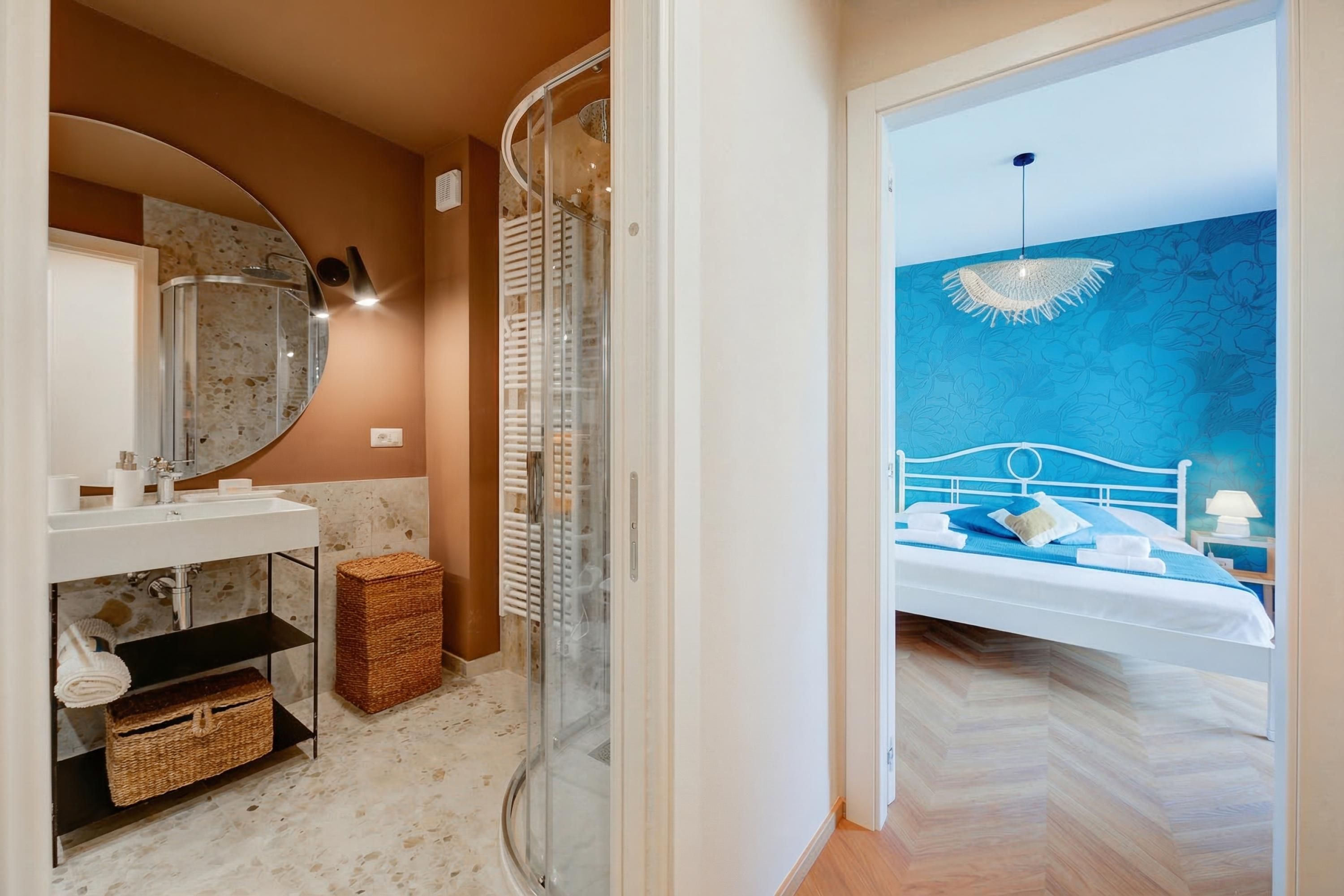 Een badkamer met een douche in een gebogen vorm, een wastafel met spiegel en een toilet.