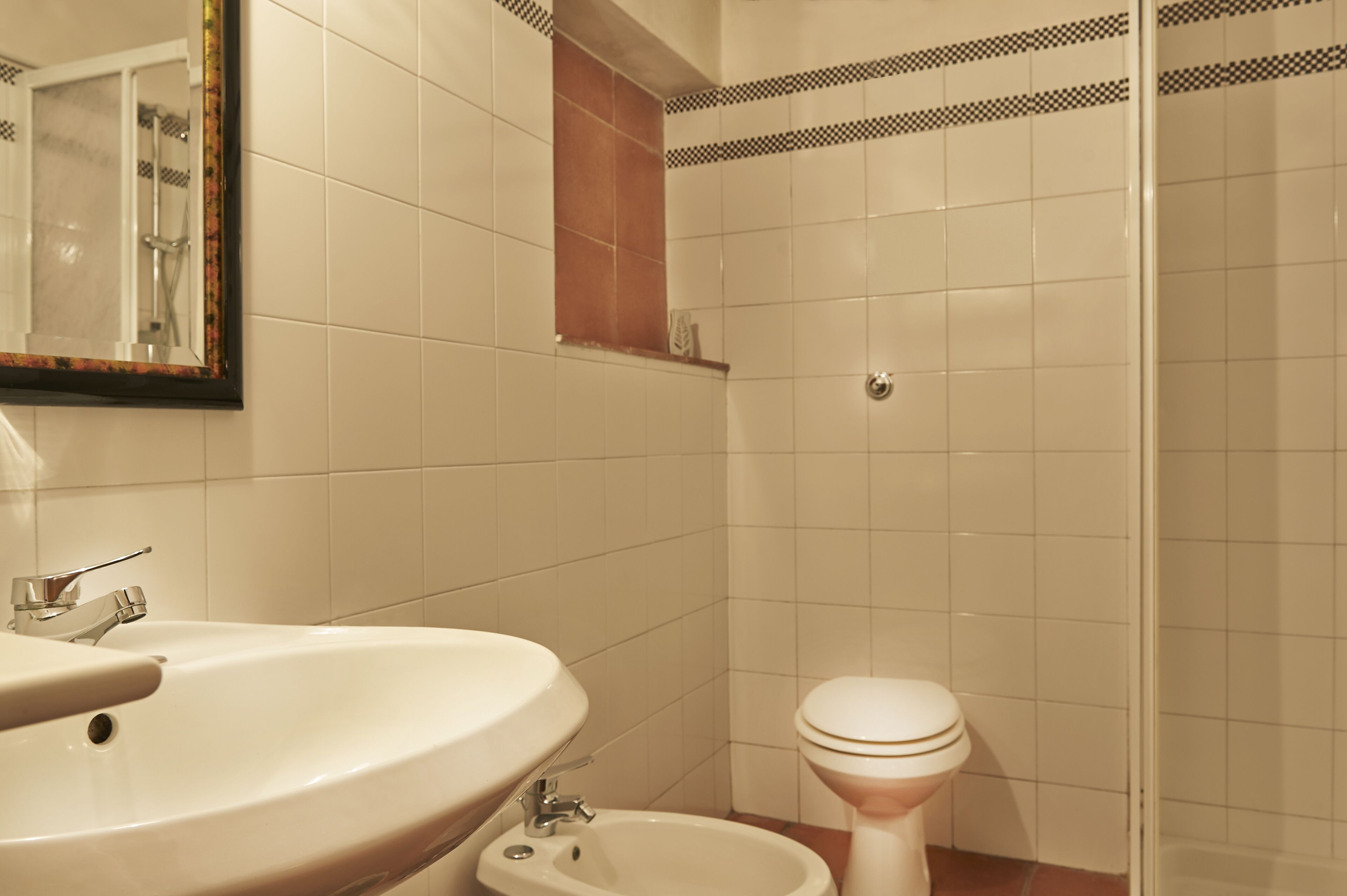 A bathroom with a sink, toilet, and shower area.