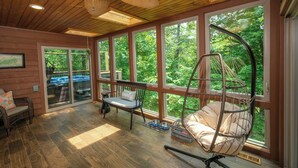A spacious room with large windows, a ceiling fan, and a hanging chair. - 3br, sleeps 10, Gatlinburg, all the amenities! (Gatlinburg)