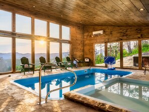 A wooden cabin with a pool, large windows, and outdoor seating.