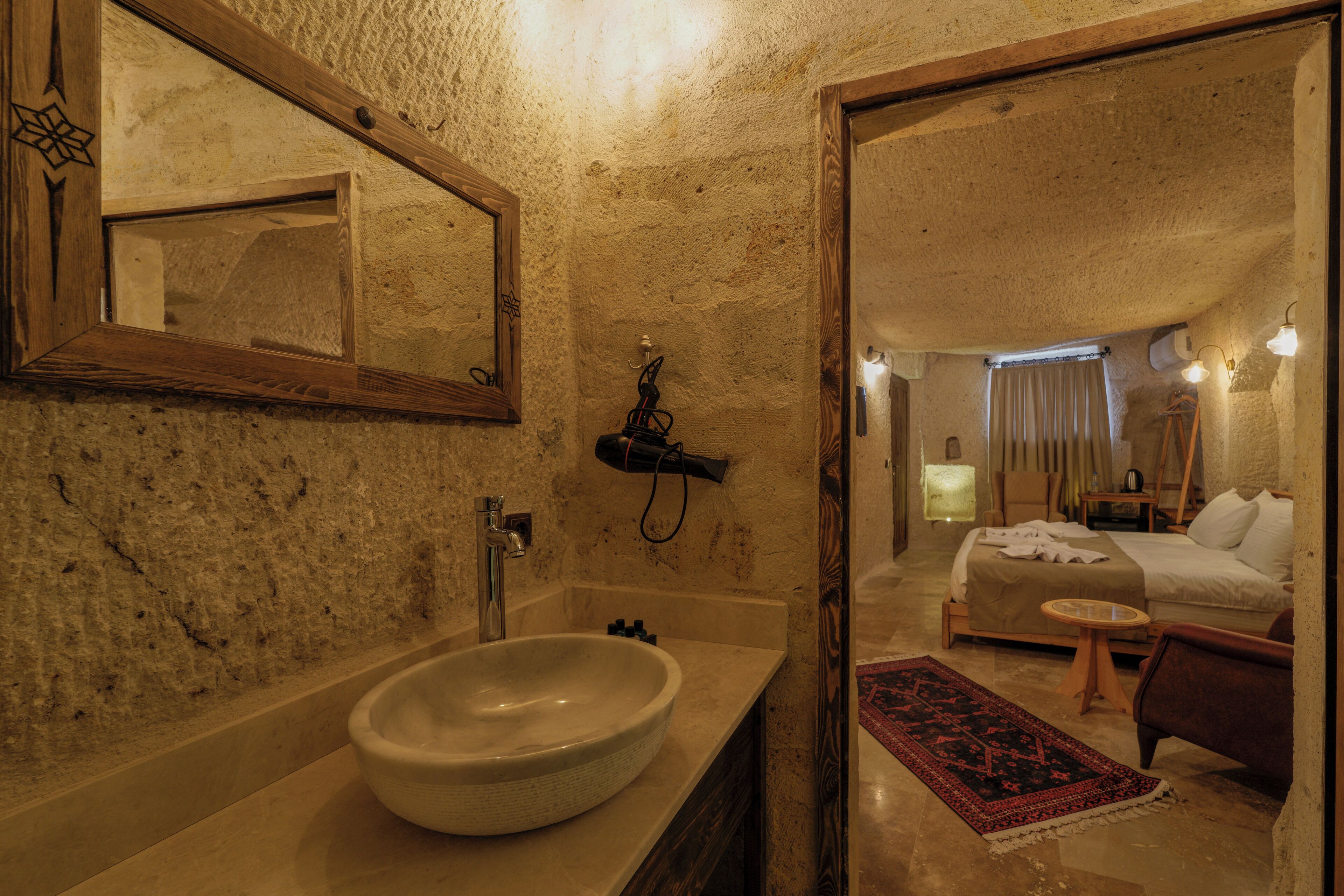 Een badkamer met een grote spiegel, een wastafel en een douche.
