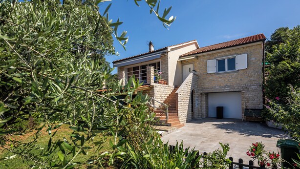A stone house with a tiled roof, a garage, and a small porch. - Colourful Seaview Apartment (Kostrena)