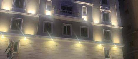 Un hotel de varios pisos con una entrada destacada y un letrero visible que indica que es un hotel.