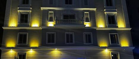 Un hôtel avec une enseigne indiquant « Ocean View Alzahra Hotel » la nuit.