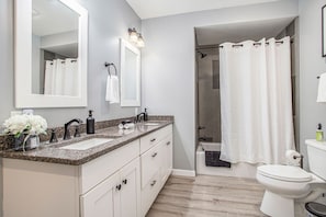 Une salle de bain moderne avec un meuble-lavabo à deux vasques, des toilettes et un espace douche.